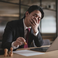 始末書に判をする疲弊した会社員の机上風景の写真