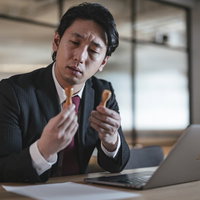 判子を押してデータ化するのに疲れた会社員男性の写真