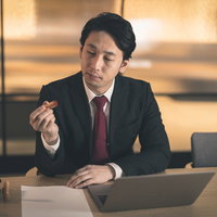 契約書に押印する会社役員の手元とスーツ姿の写真