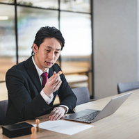 契約書に印鑑を押す判子を手にしたビジネスマンの写真