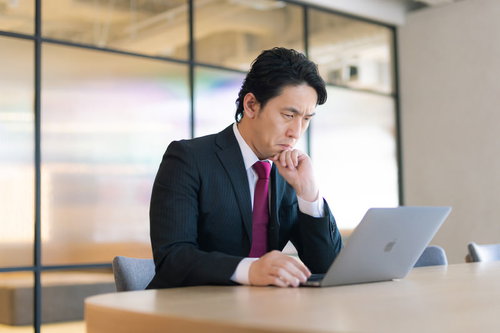 業績の下がり具合を懸念してデスクで考え込む役員