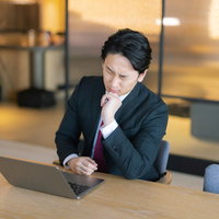 ノートパソコンを前にまったくいいアイデアが思いつかない男性の写真