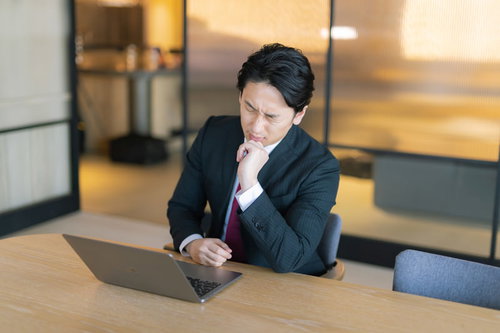 ノートパソコンを前にまったくいいアイデアが思いつかない男性