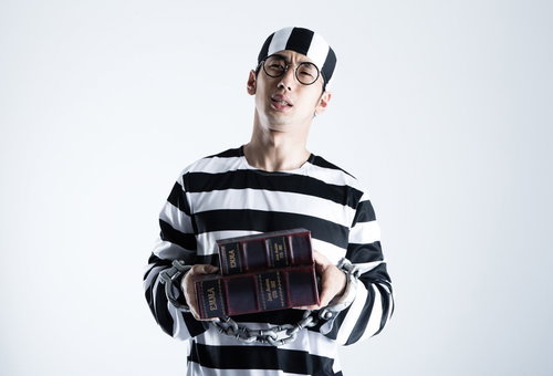 同じ本のハードカバーと文庫本を購入するハロウィン囚人コスプレの男性