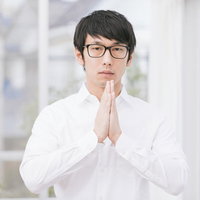 おててのしわとしわをあわせても不幸せな眼鏡の男性の写真
