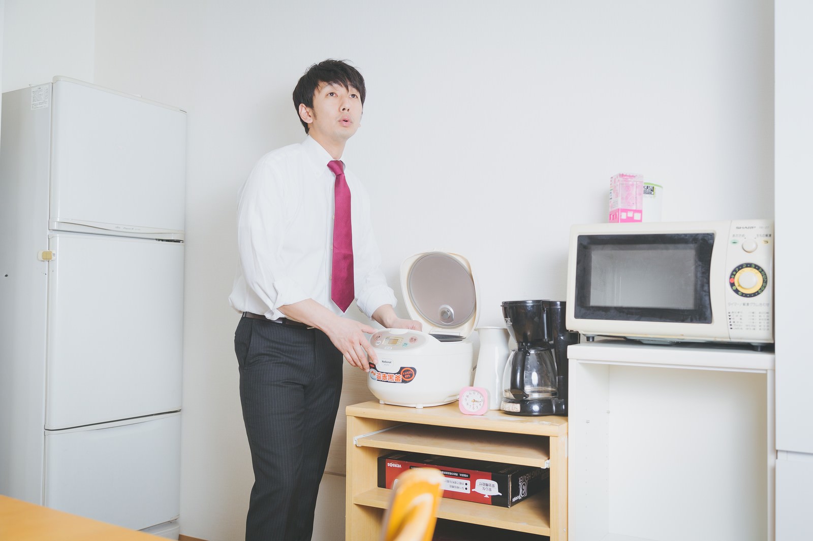 数ヶ月前のお米を見つけ遠い目をする新米教師の男性［モデル：大川竜弥］