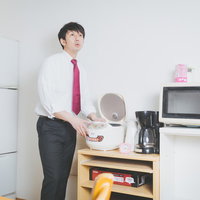 数ヶ月前に炊いたお米を見つけ遠い目をする新米教師の写真