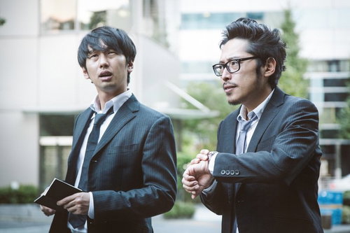 本日分の締切りを気にするジャーナリストと記者