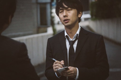 徹夜明けでフラフラの新聞記者の写真