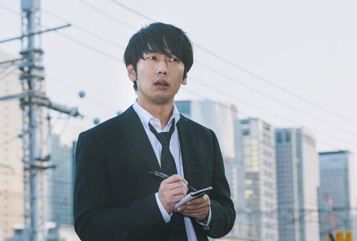 都会でスマートフォンを手に情報確認するジャーナリスト男性