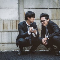 取材現場で情報を交換するジャーナリストのコンビの写真