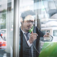 公衆電話から解散騒動の特ダネを伝える眼鏡の記者の写真