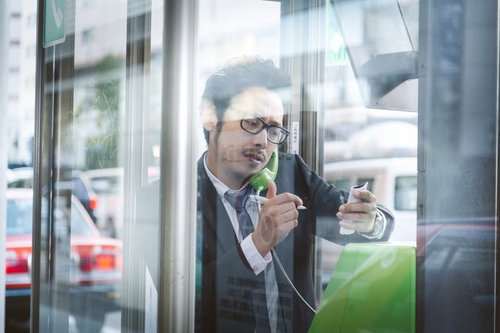 公衆電話から解散騒動の特ダネを伝える眼鏡の記者