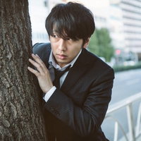 尾行中に木陰にとっさに身を隠すジャーナリスト姿の男性の写真