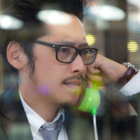 電話ボックス内で張り込む眼鏡のジャーナリストの写真