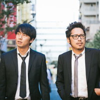 張り込み中に言い争うスーツ姿の上司と部下の写真