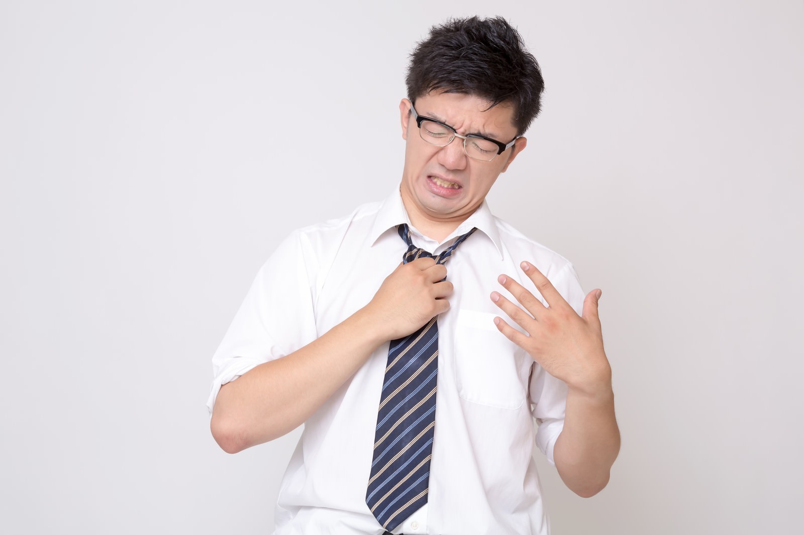 猛暑でネクタイを引っ張る半袖シャツの眼鏡の男性［モデル：OZPA］