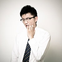 虫歯が痛くて仕事にならないサラリーマンの写真