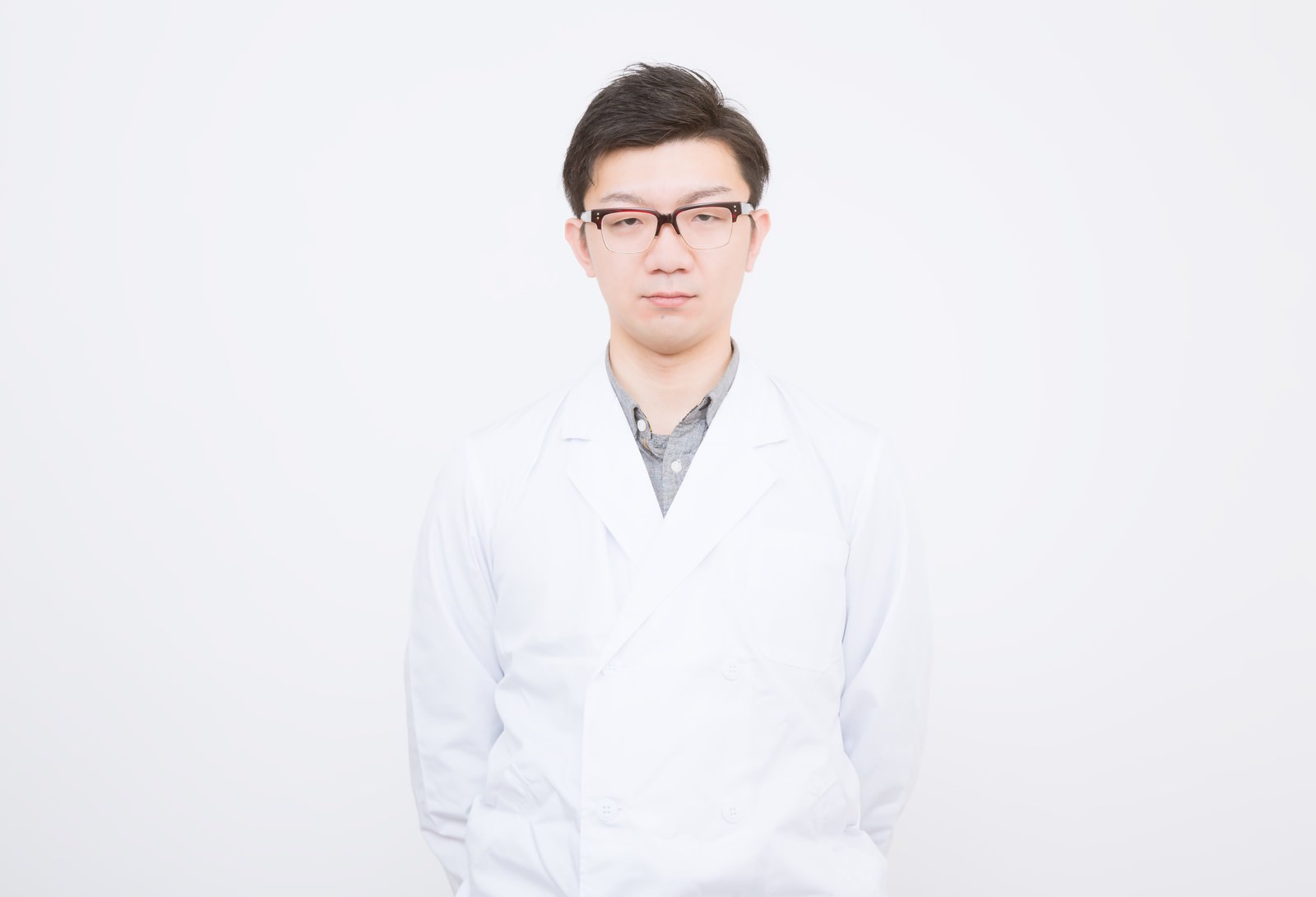 正面を向いて立つ眼鏡をかけた白衣のドクターr［モデル：OZPA］