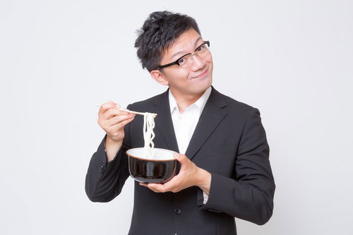 不味そうな素うどんをすくう素うどん面（ヅラ）のビジネスマン