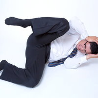 頭を抱えてジタバタする男性の写真