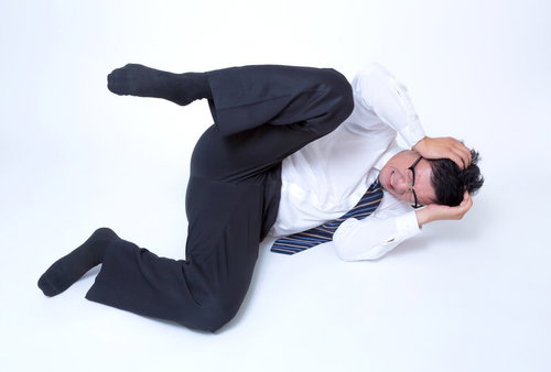 頭を抱えてジタバタする男性