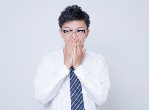 両手で顔を覆って驚くビジネスマン