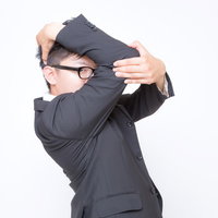 上着を頭にかざして祝福を求める男性の写真