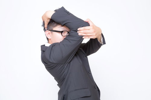 上着を頭にかざして祝福を求める男性