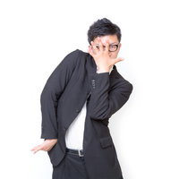 手を広げてクラッカーで遊ぶサラリーマンの写真