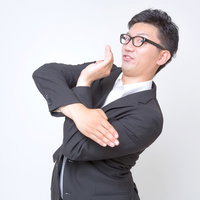 右手を顔の横に上げて左上を見る男性の写真