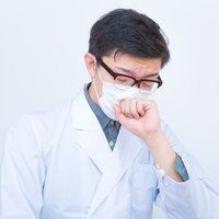 マスクをして咳をするドクターの不養生な医療従事者の写真