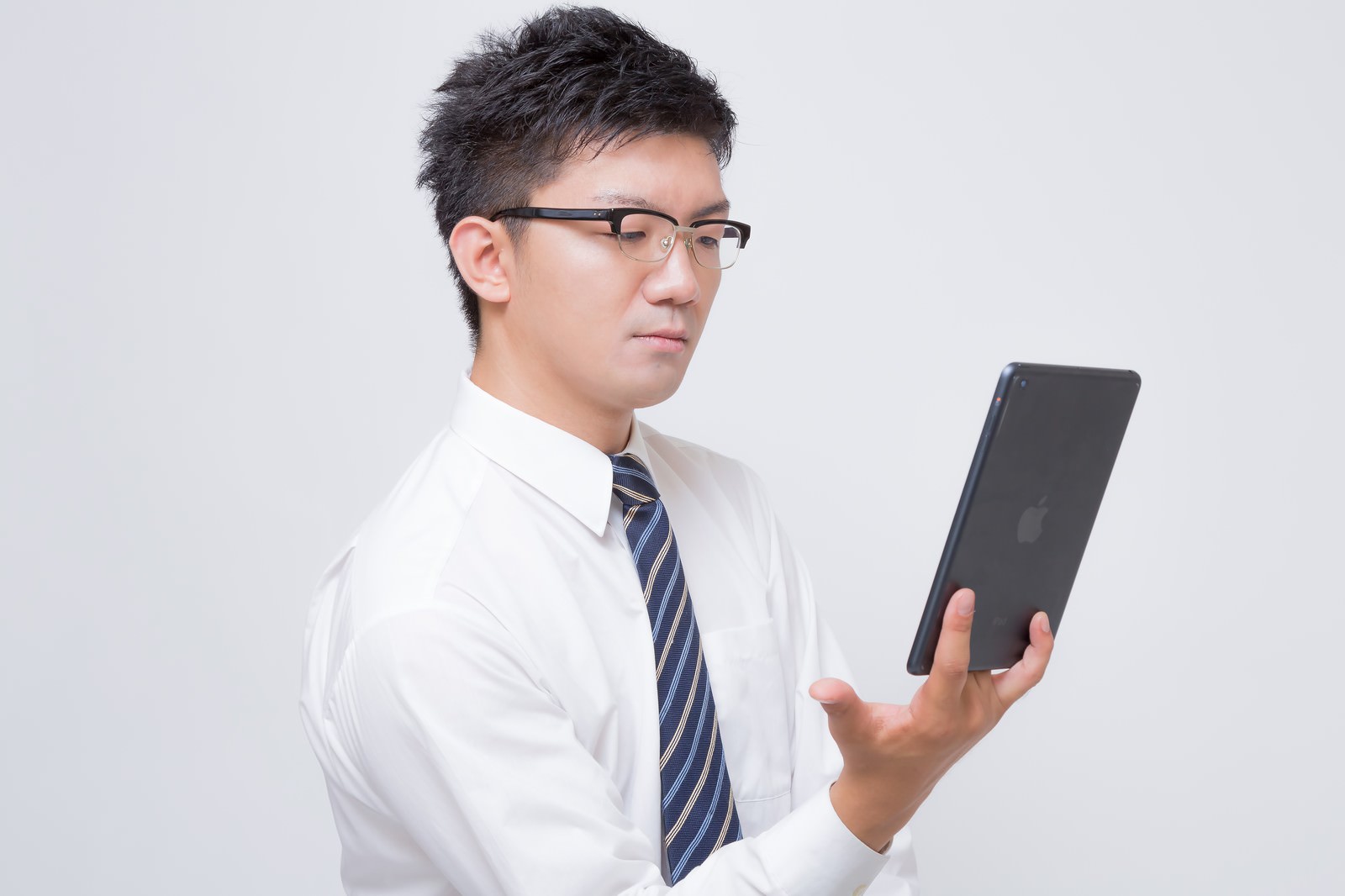 タブレットで電子書籍を読む眼鏡のビジネスマン［モデル：OZPA］