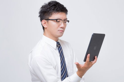 iPadで電子書籍を読む眼鏡のビジネスマン