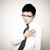 胸の痛みを訴えるビジネスマンの写真