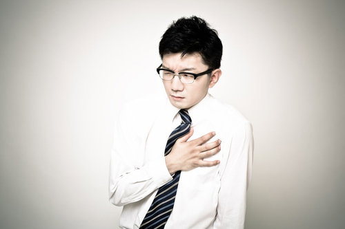 胸の痛みを訴えるビジネスマン