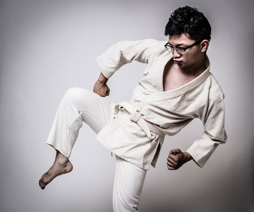 膝蹴りをきめる白帯の男性