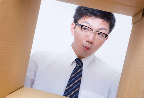 ダンボールの中身を覗き込むサラリーマン