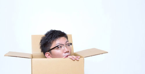 開封したダンボールからヒョコッと顔を出す男性