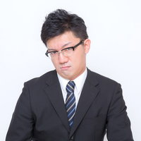 「おこ」な表情のスーツ姿の男性の写真