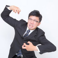 「激おこぷんぷん」で腕を上げる男性の写真