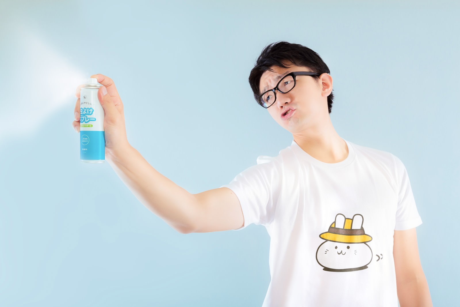 青いスプレー缶を右手で持ち上げる眼鏡の男性［モデル：OZPA］