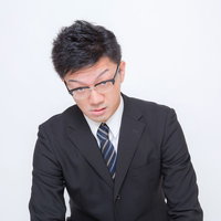 下を向く圧迫面接中のサラリーマンの写真