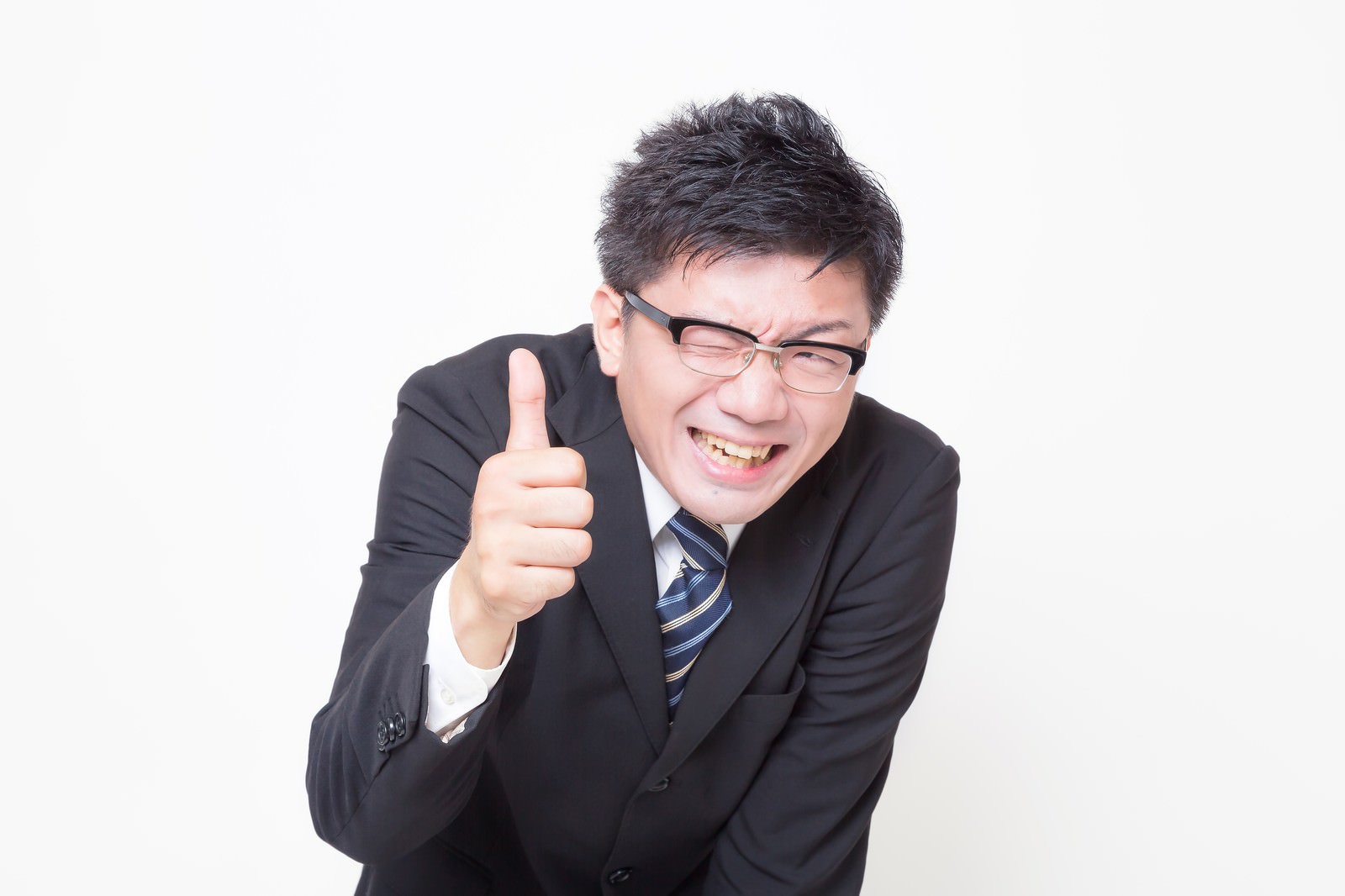 眼鏡をかけたスーツ姿の男性が右手の親指を立てながら、笑顔で身を乗り出している