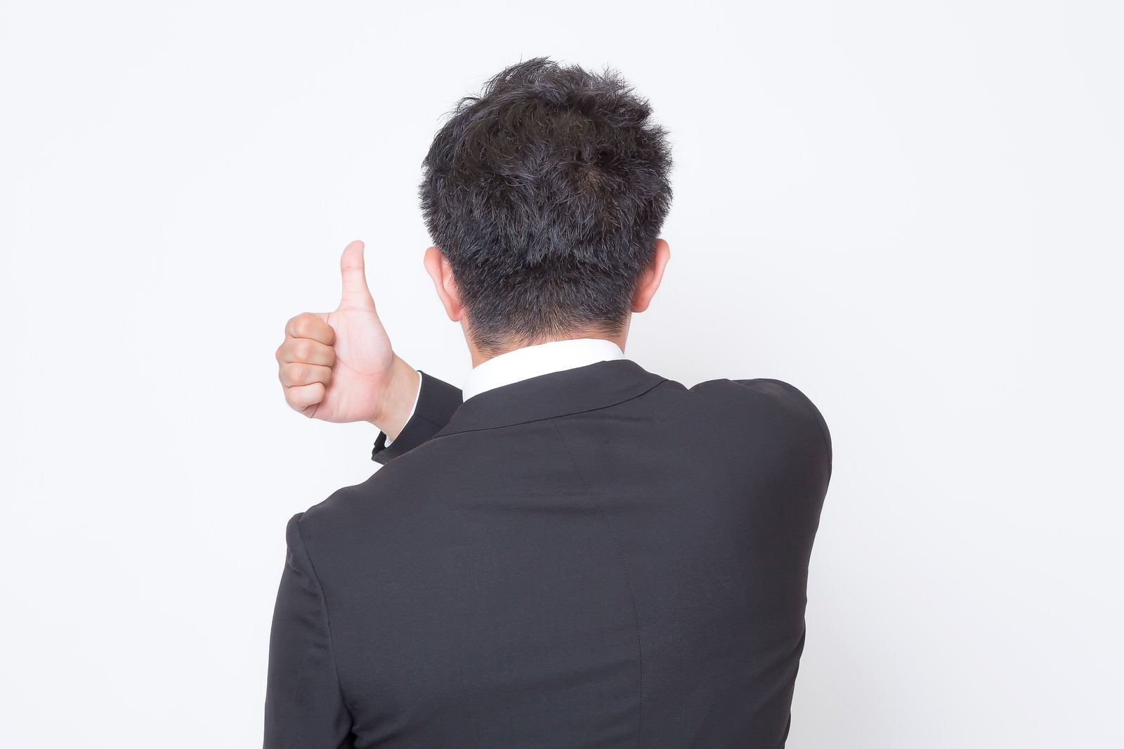 後ろ向きで親指を立てるスーツの男性［モデル：OZPA］