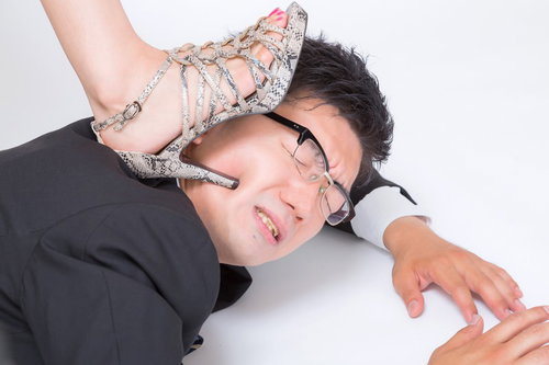 ハイヒールで踏まれる仰向けの男性