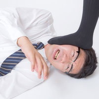 踏みつけられるダメ亭主のサラリーマンの写真
