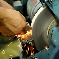 研磨機から飛び散るオレンジ色の火花の写真