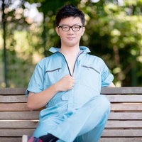 現場仕事をやり終えた作業着姿の若い男がベンチで一息の写真