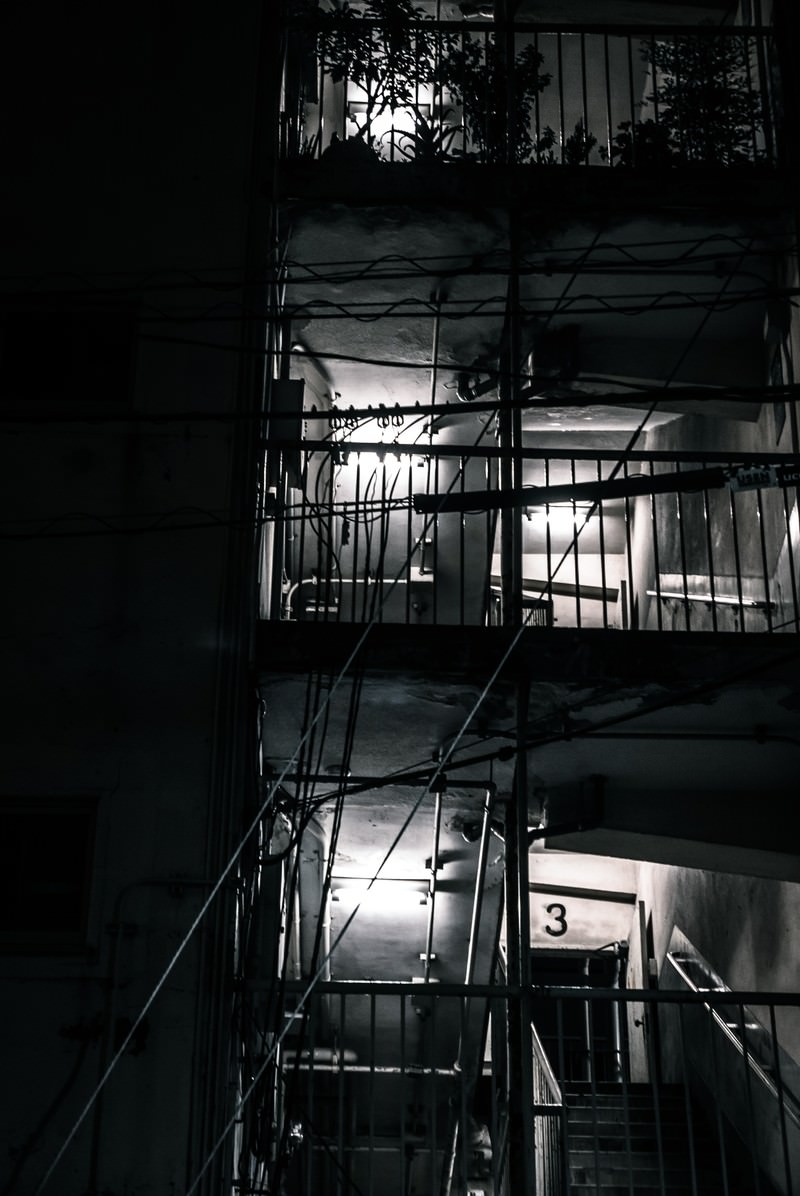 深夜に照らされたマンションの古い非常階段